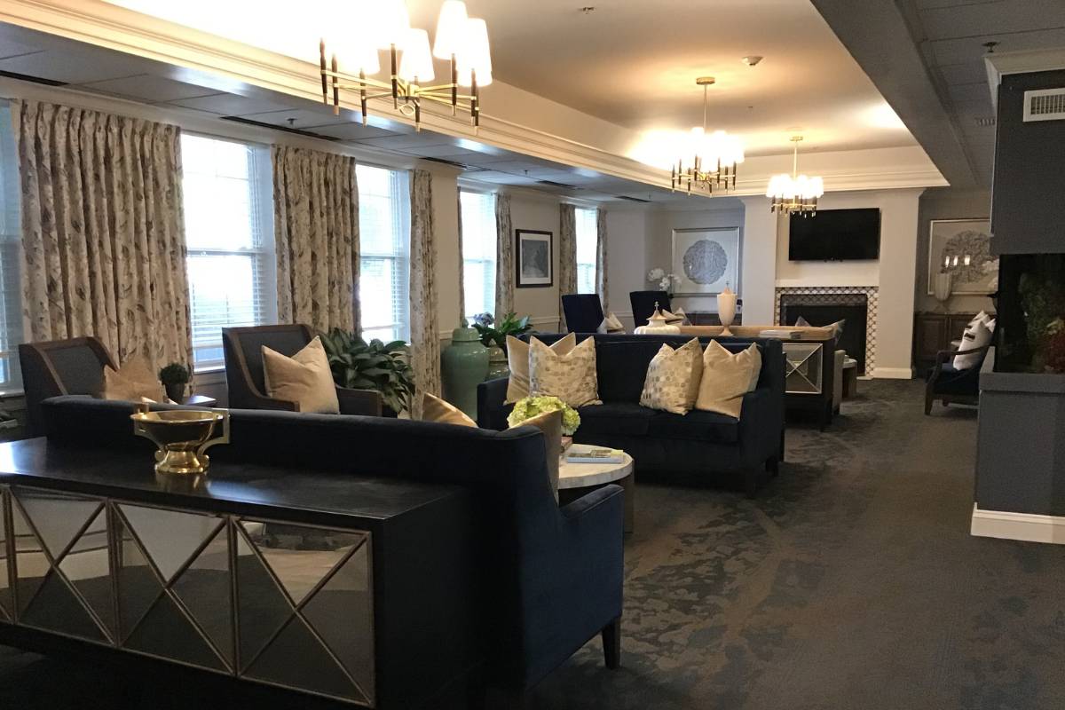 Main parlor at Dresher Estates with console tables, couches, and chairs around a fireplace.