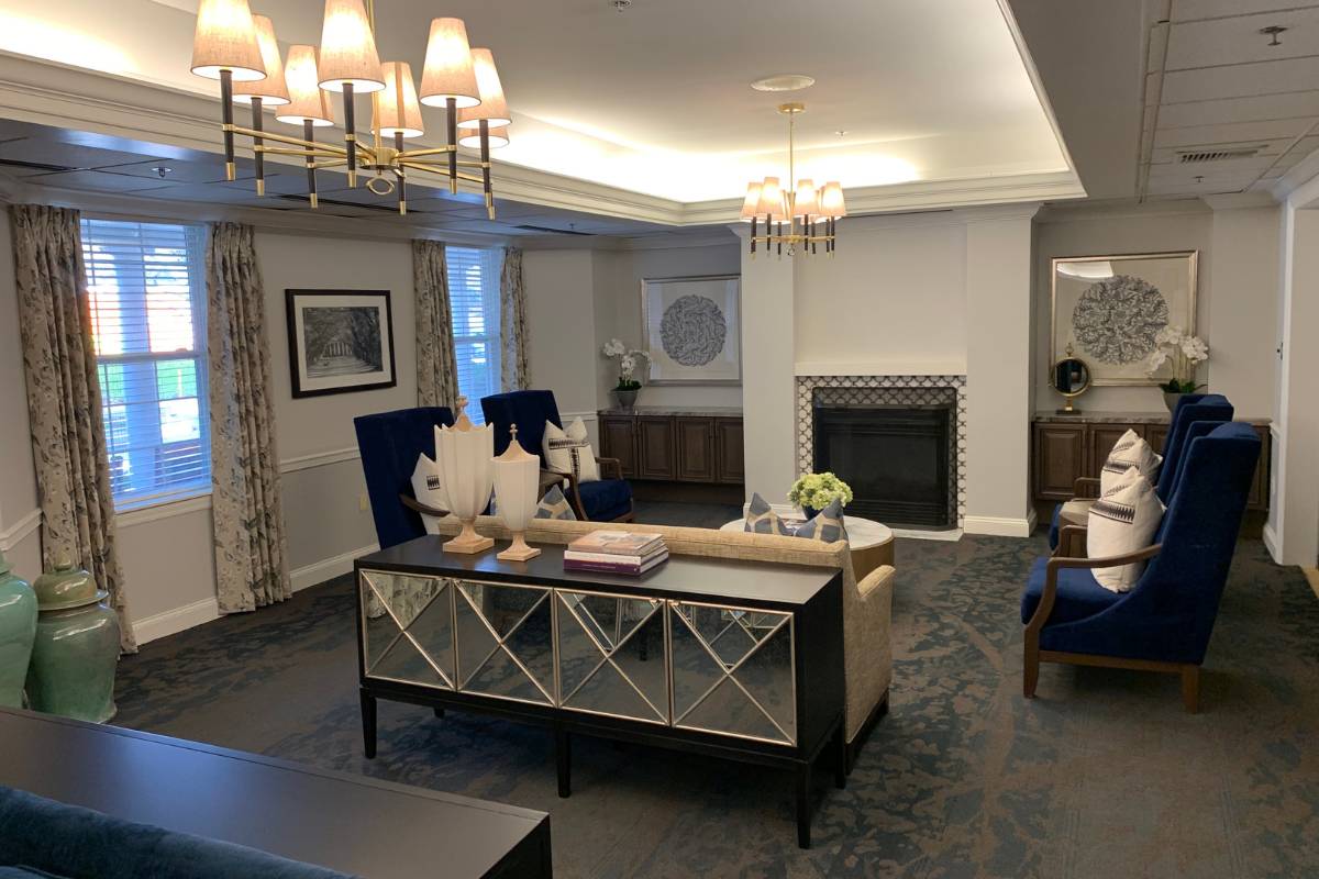 Main parlor at Dresher Estates with console tables, couches, and chairs around a fireplace.