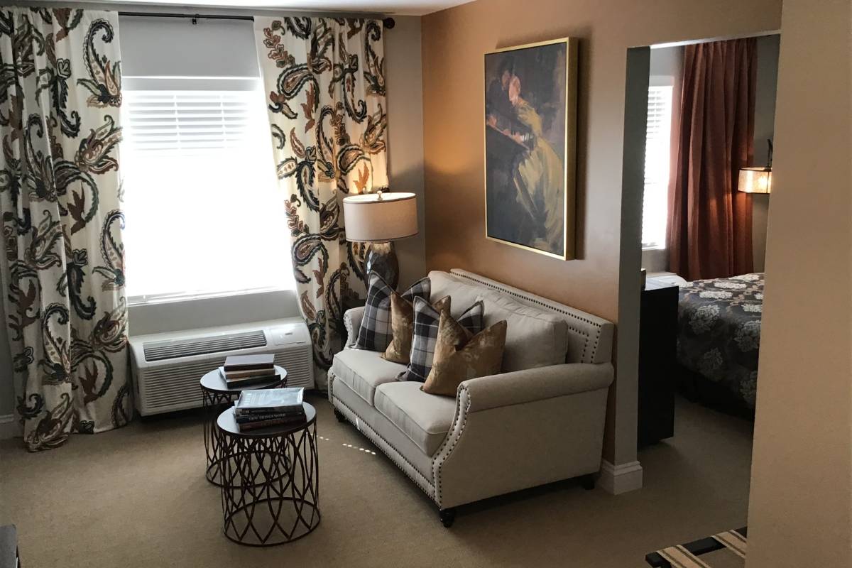Model living room with a couch, throw pillows, and side tables.