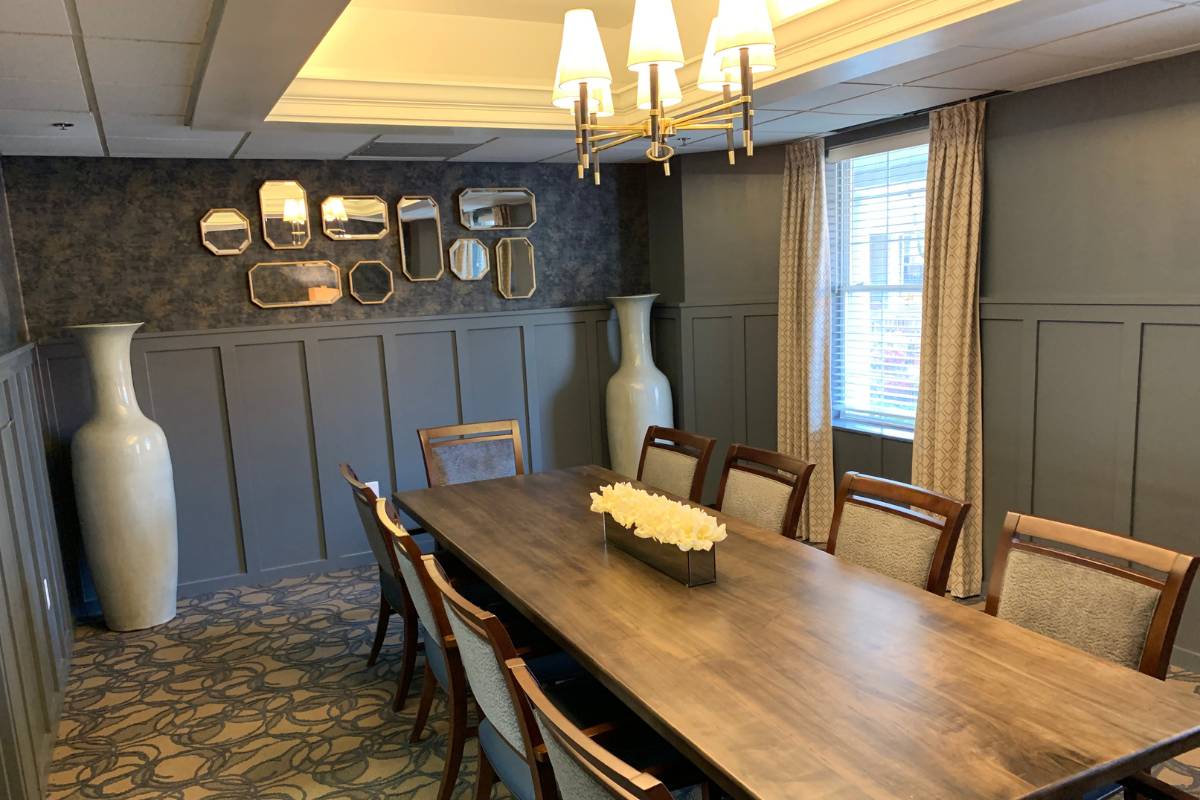 Private Dining room at Dresher Estates, with mirrors decorating the wall, and a long tables for plenty of seating.